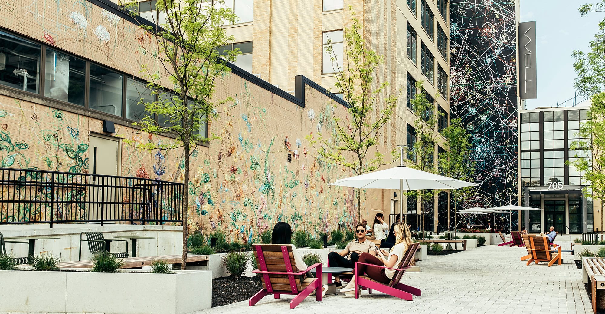 Group of friends enjoying a sunny day in an urban courtyard with art installations