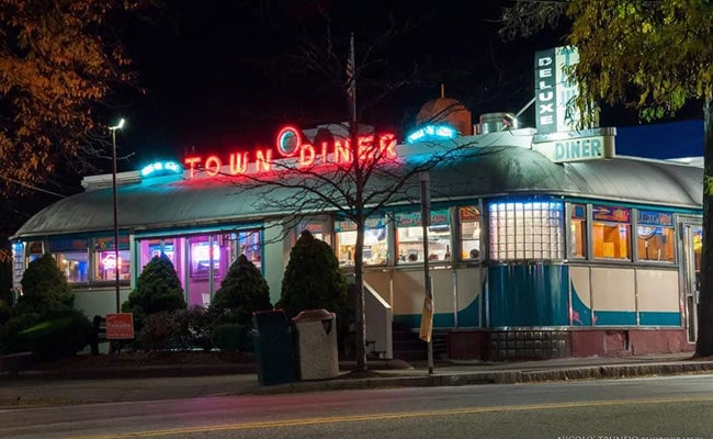 Classic American diner, Deluxe Town Diner, lit up with neon signs in the evening