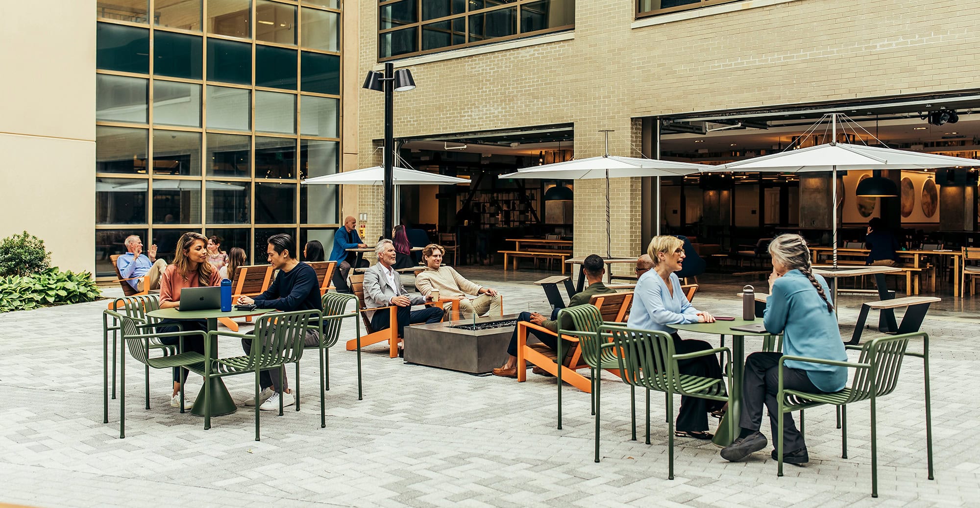 Courtyard with comfortable seating, umbrellas, and people socializing