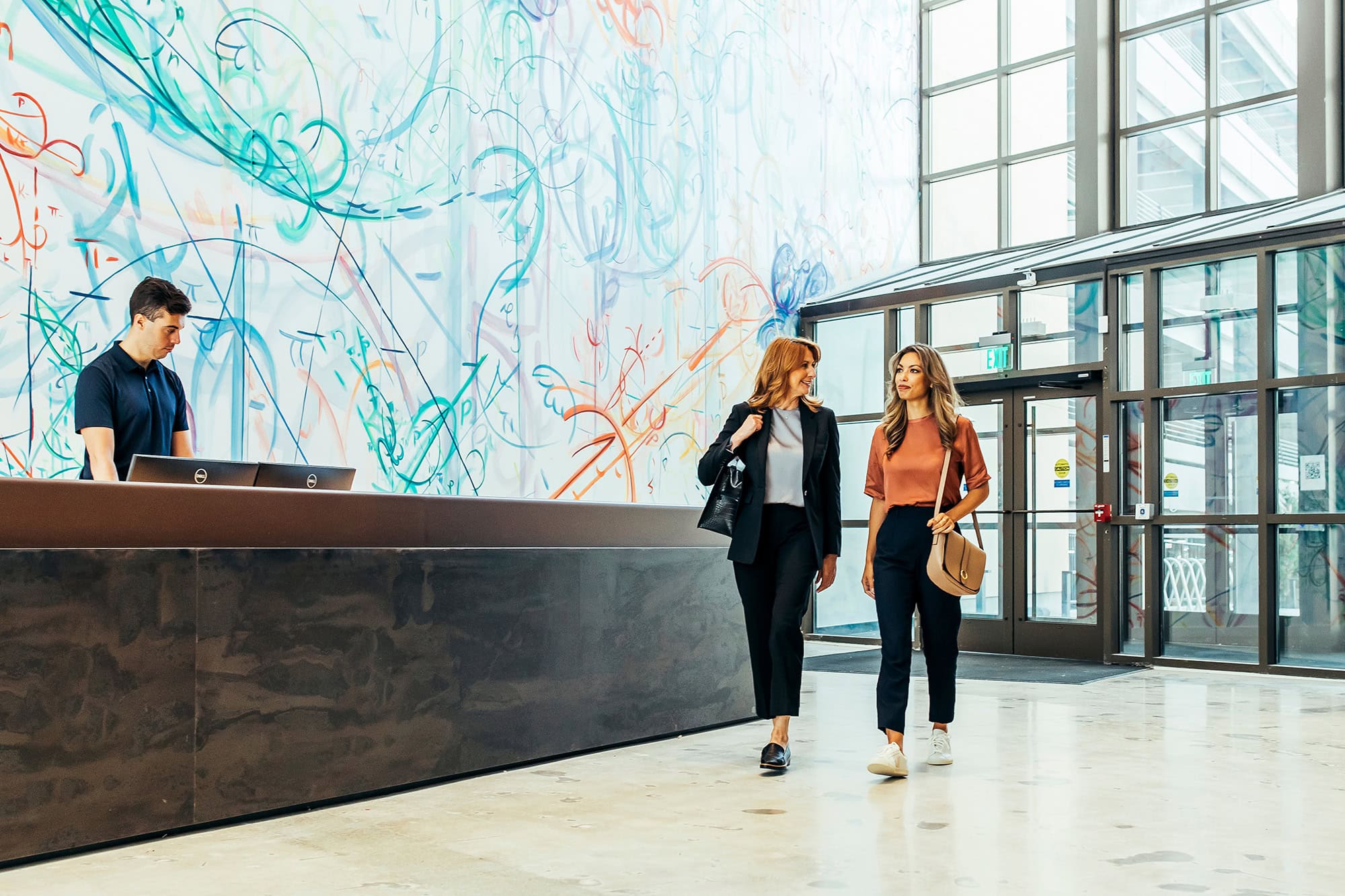Modern office lobby with a receptionist and professionals in conversation