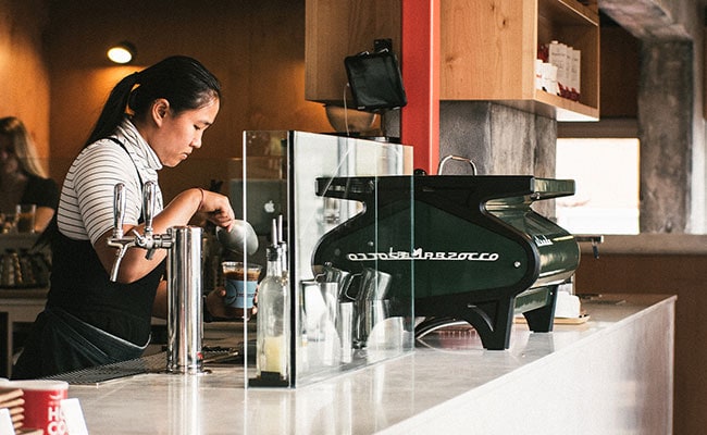 Barista preparing coffee at a stylish café counter