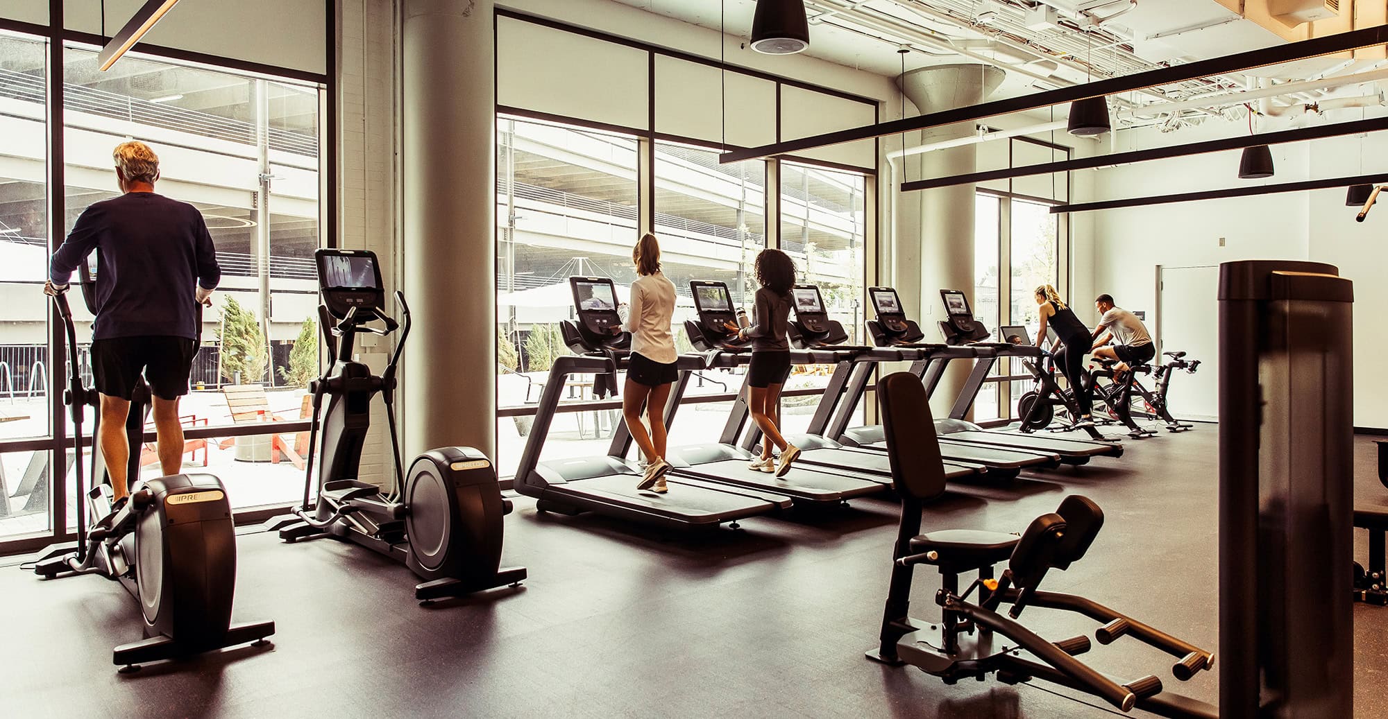Fitness center featuring treadmills and people working out