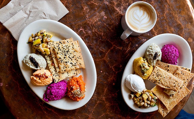 Colorful spread of hummus, bread, and coffee at Sofra Bakery, showcasing Mediterranean flavors