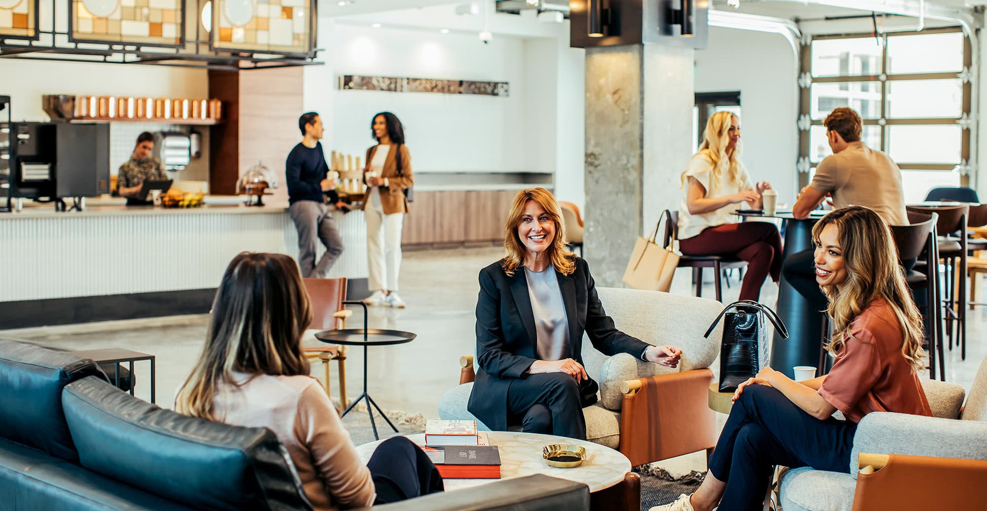 Bright and airy coffee lounge with patrons engaged in conversation and working on laptops